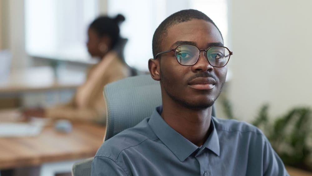 A young professional early in his career in an open plan office