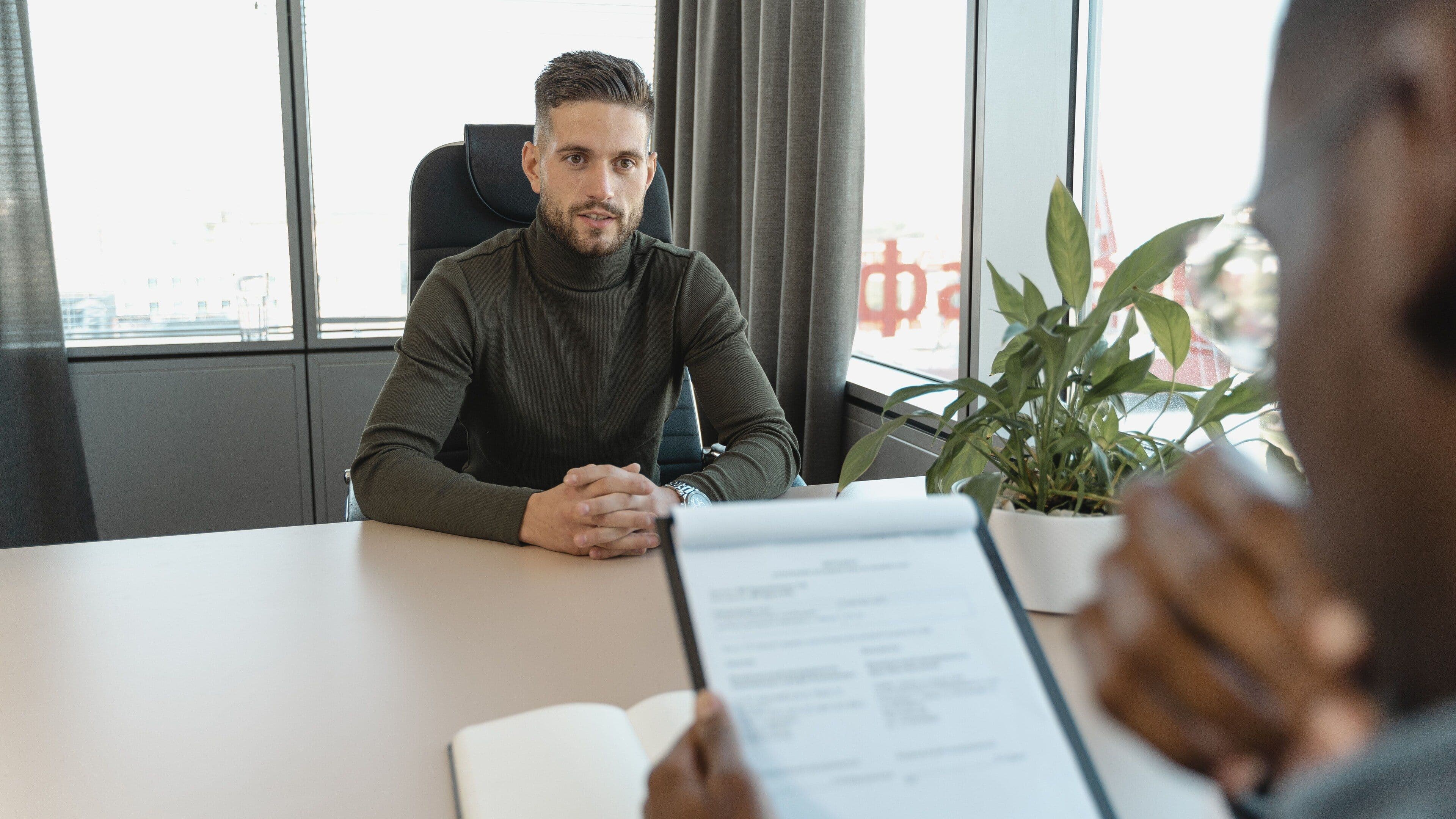 Job candidate seated across the table from an interviewer holding a resume