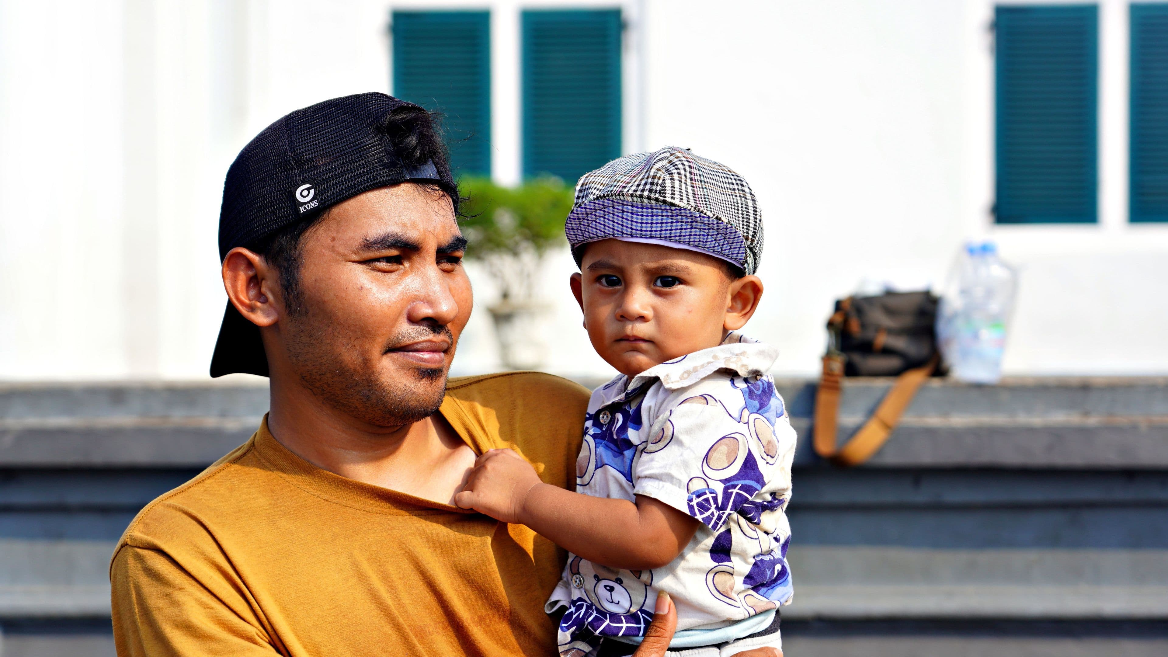 A father holding his young child outdoors